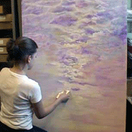Student painting a large canvas of the cloudy purple sky